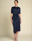 Woman wearing a navy blue dress against a beige background